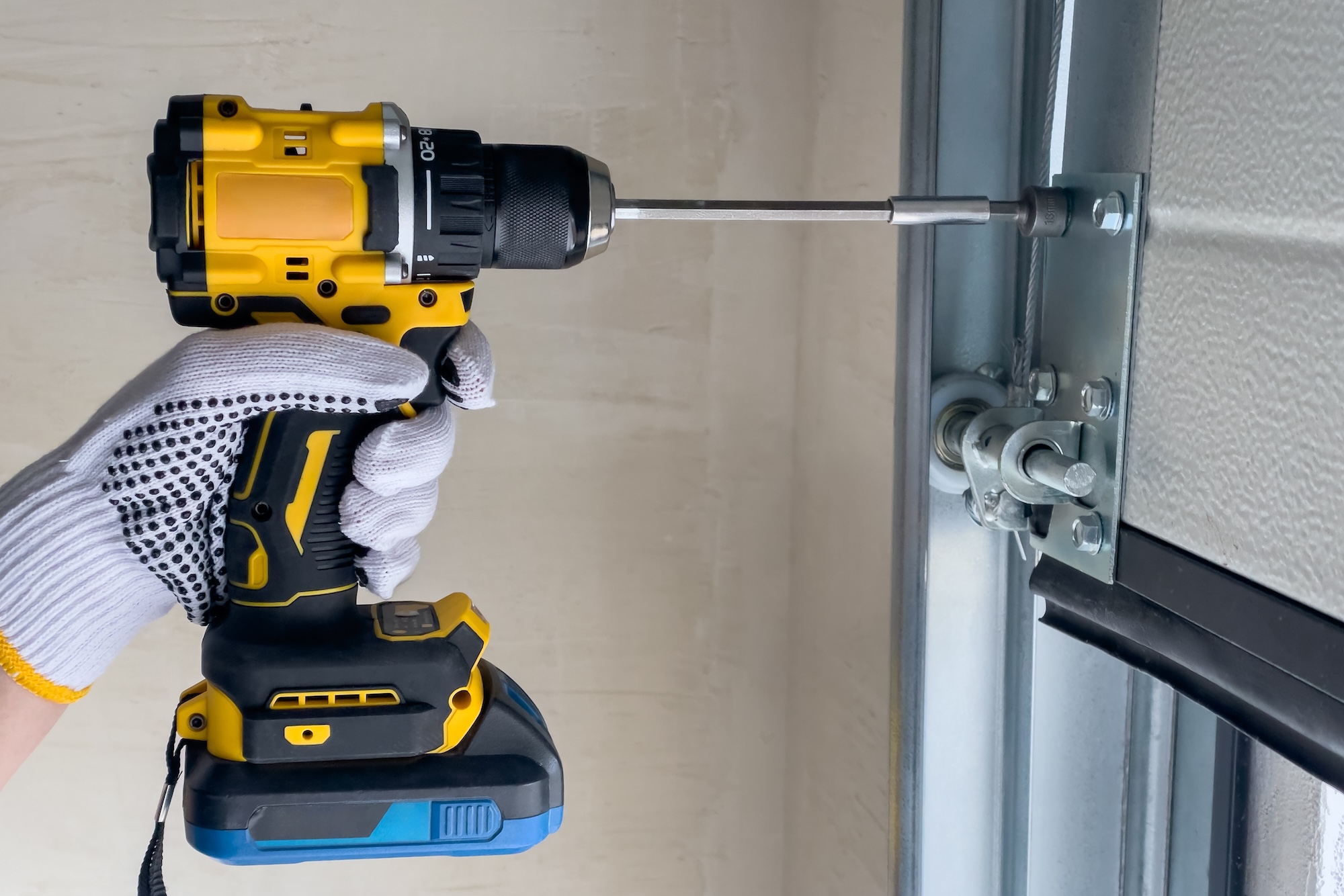 A craftsman assembles sectional doors using a screwdriver. Garage Door Repair in Albuquerque
